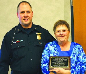 Wayne Police Chief Jason Wright presents Pat Dawson with a plaque to honor her 27 years of service as a crossing guard. 