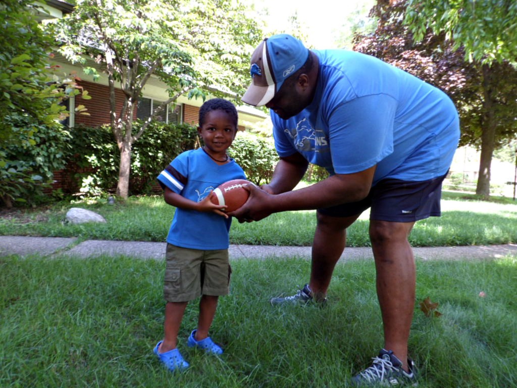 Scotty Jr., age 3, learns the fundamentals of football from his dad.