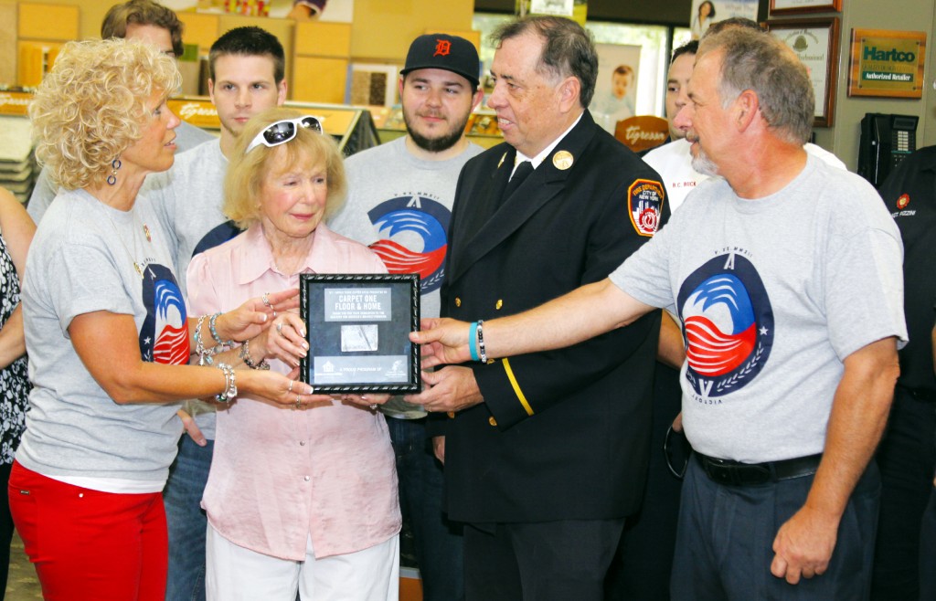 Cathy Buchanan, Frances Francavilla, owner, and Robert Francavilla receive a piece to the World Trade Center from retired New York Battalion Chief Ed Breen. Photo by John P. Rhaesa