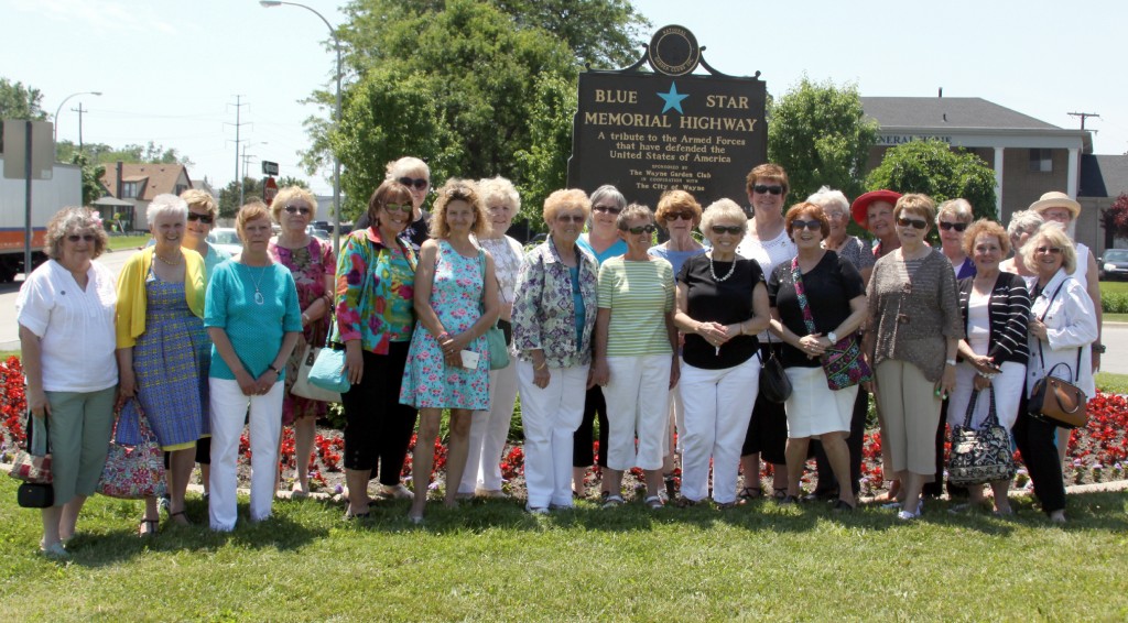 Members of the Wayne Garden Club stand in front of the new Blue Star Memorial Highway marker on Michigan Avenue in the median in front of Harry J. Will Funeral Home. Photo by John P. Rhaesa