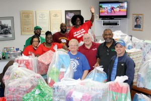 Santa’s UAW helpers Patty Martin (Co-Chair),  Mike Smith (Vice President), Anderson Robinson Jr. (President),  Bill Johnson Jr. (Financial Secretary). Back, Danita Brantley (Editor), Ulysses Edmonson,  Ebony Kennedy (Chair), Fernando Merida (District Committee) and Judy Reynolds (Secretary) show off some of the gifts being donated to people in the community. 